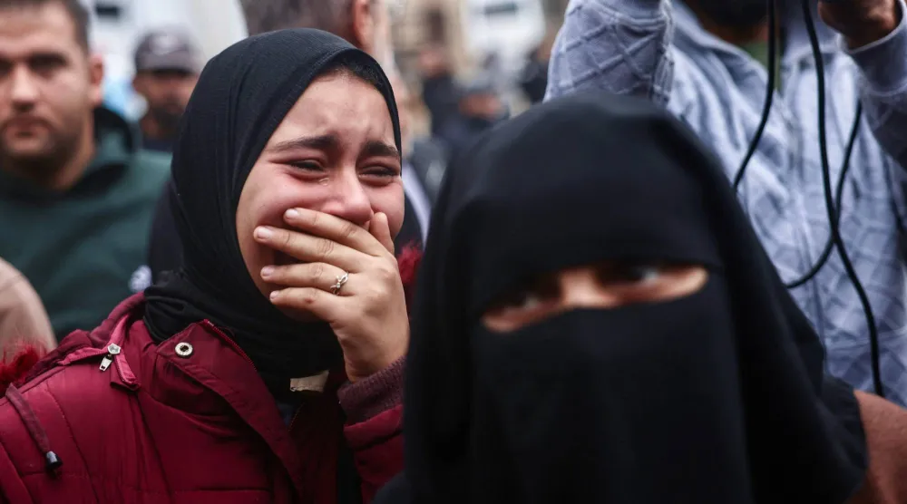 فلسطينيات يبكين أقاربهن الذين قتلوا في غارات إسرائيلية على قطاع غزة (أ.ف.ب)