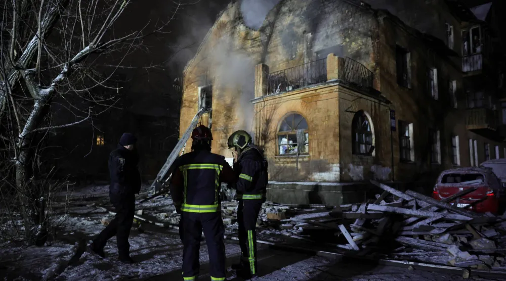 إطفائيان في محيط مبنى أصيب بالضربات الجوية الروسية على كييف (رويترز)