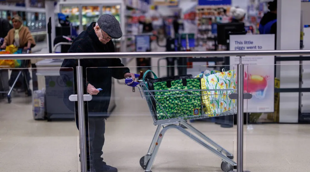 شخص مسن يغادر متجراً في شرق لندن (إ.ب.أ)