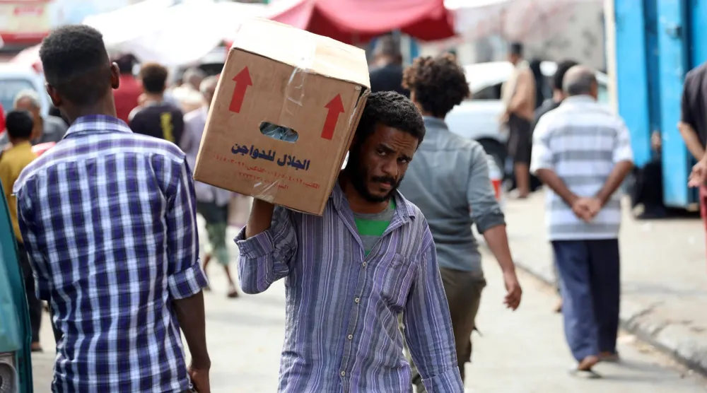 يمنيون يمشون في إحدى أسواق مدينة عدن وسط حالة من الأمن والهدوء (إ.ب.أ)