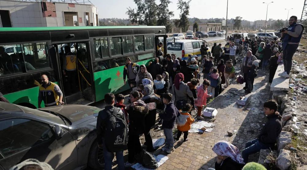 مواطنون ينتظرون إجلاءهم من حي الشيخ مقصود في حلب (رويترز)