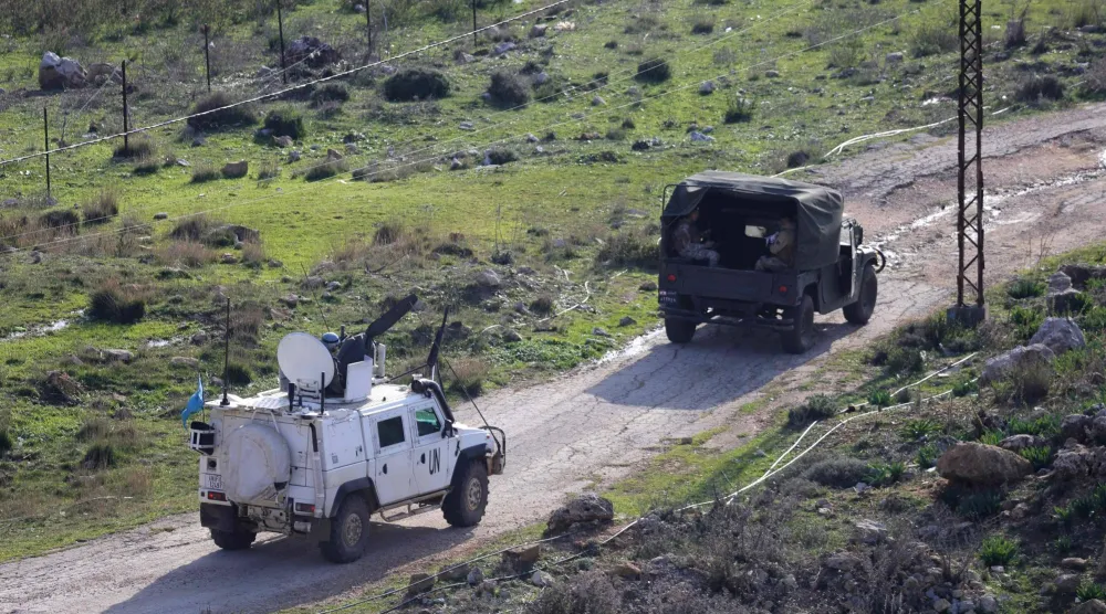 جنود حفظ السلام التابعون لقوة الأمم المتحدة المؤقتة في لبنان (اليونيفيل) بدوريات في مركبات برفقة جنود لبنانيين في منطقة بويضة بمحافظة مرجعيون، قرب الحدود مع إسرائيل في جنوب لبنان (أ.ف.ب)