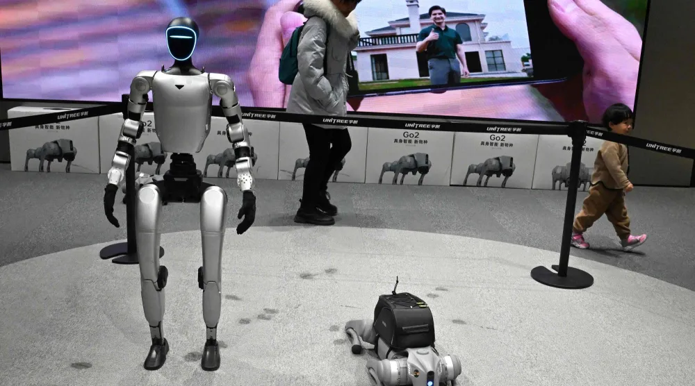 زوار يمرون بجوار الروبوتات المعروضة في أول متجر بيع بالتجزئة (أ.ف.ب)