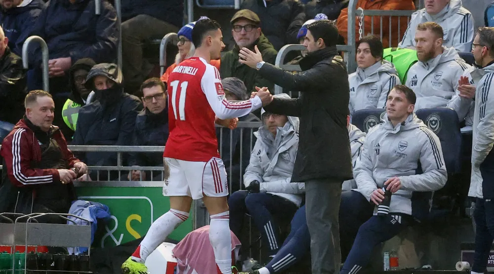 غابرييل مارتينيلي يحتفل مع مدربه ميكل أرتيتا بالفوز على بورتسموث (رويترز)