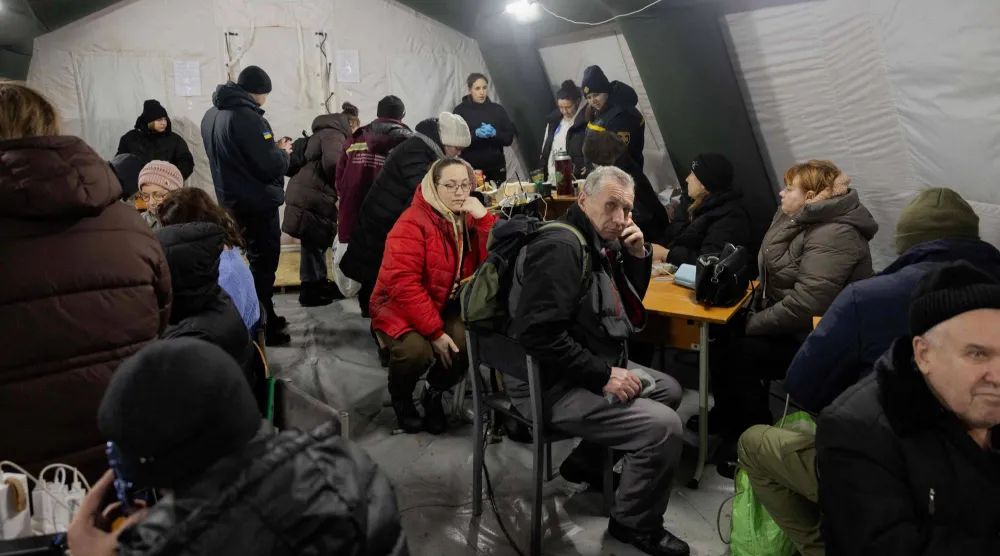 أناس يشحنون أجهزتهم في خيمة مزودة بالتدفئة في كييف يوم أمس (ا.ف.ب)