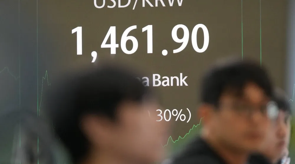 يراقب المتعاملون شاشات تعرض سعر صرف العملات الأجنبية بين الدولار الأميركي والوون الكوري الجنوبي في بنك هانا بسيول (أ.ب)