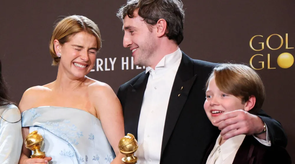 جيسي باكلي وبول ميسكال وجاكوبي جوب يقفون مع جائزة أفضل فيلم درامي عن فيلم «هامنت» (رويترز)