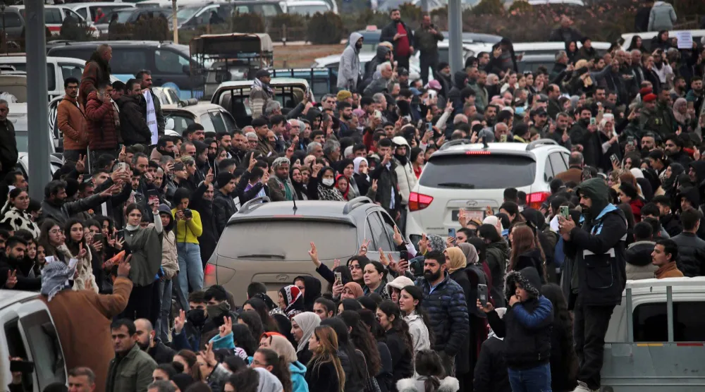 مواطنون تجمعوا حول مركبات تنقل مقاتلين أكراداً من مدينة حلب الشمالية أمس الأحد (أ.ف.ب)