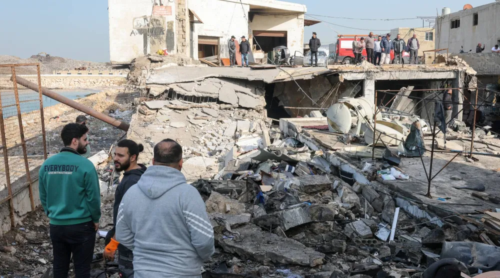 سكان يتفقدون الأضرار الناتجة عن غارات إسرائيلية استهدفت المنطقة الصناعية في صيدا عاصمة جنوب لبنان (إ.ب.أ)