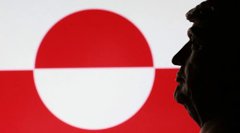 صورة مركّبة تظهر الرئيس الأميركي دونالد ترمب ينظر إلى علم غرينلاند (رويترز)