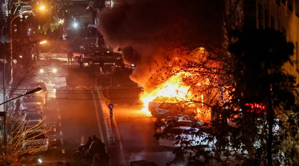  Cars burn in a street during a protest over the collapse of the currency's value, in Tehran, Iran, January 8, 2026. Stringer/WANA (West Asia News Agency) via Reuters