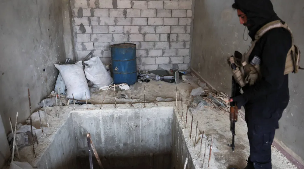 عنصر أمن سوري يعاين نفقا لـ"قسد" في حلب بعد انسحابها الأحد (رويترز)