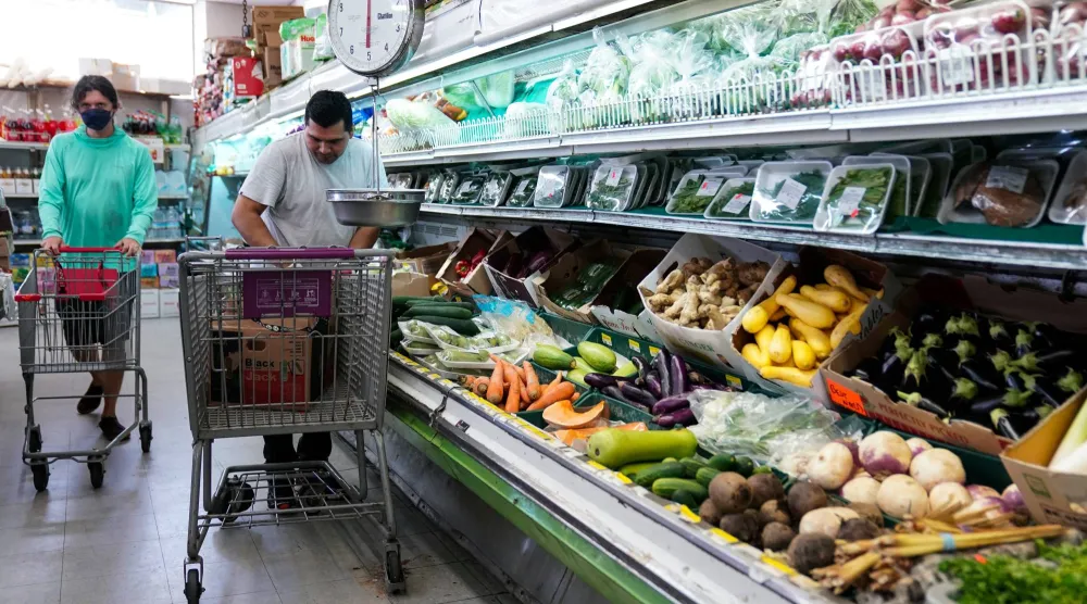 متسوق يرتب الخضراوات والفواكه في سوبر ماركت «بيست وورلد» في حي ماونت بليزانت بواشنطن (رويترز)