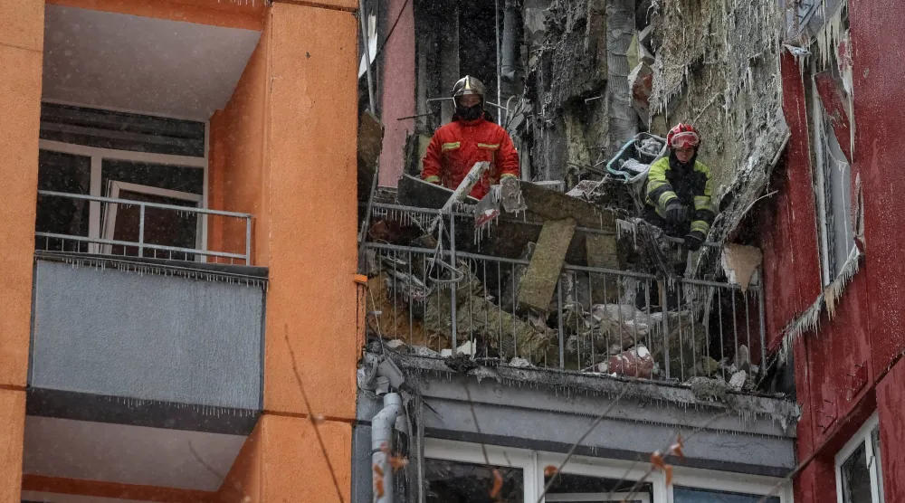  رجال إنقاذ في مبنى سكني استُهدف بغارة جوية روسية بطائرة مسيرة (رويترز) 