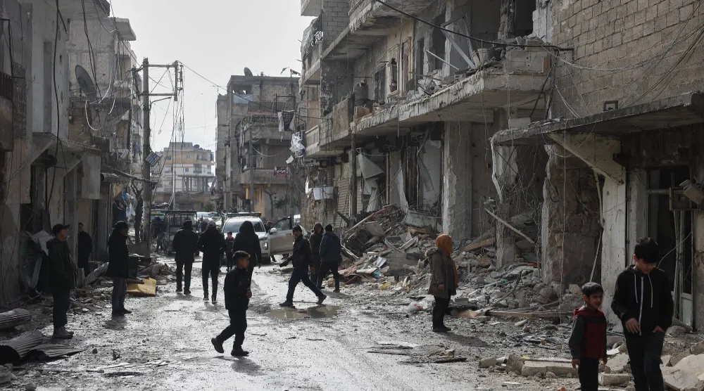 سوريون يتفقدون الأضرار التي لحقت بالأبنية في حي الشيخ مقصود بحلب بعد الاشتباكات الأخيرة (أ.ب) 