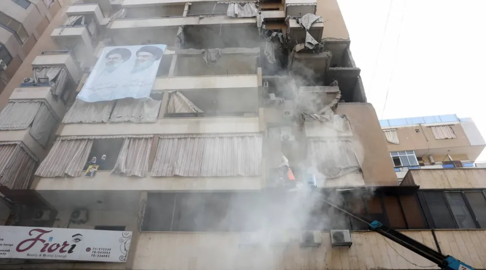 Beyrut'un güney banliyölerinde lider Heysem Tabatabai'nin suikastında hedef alınan bir binanın üzerinde Hizbullah eski genel sekreterleri Hasan Nasrallah ve Haşim Safiyuddin'in fotoğrafı (Arşiv- Reuters)