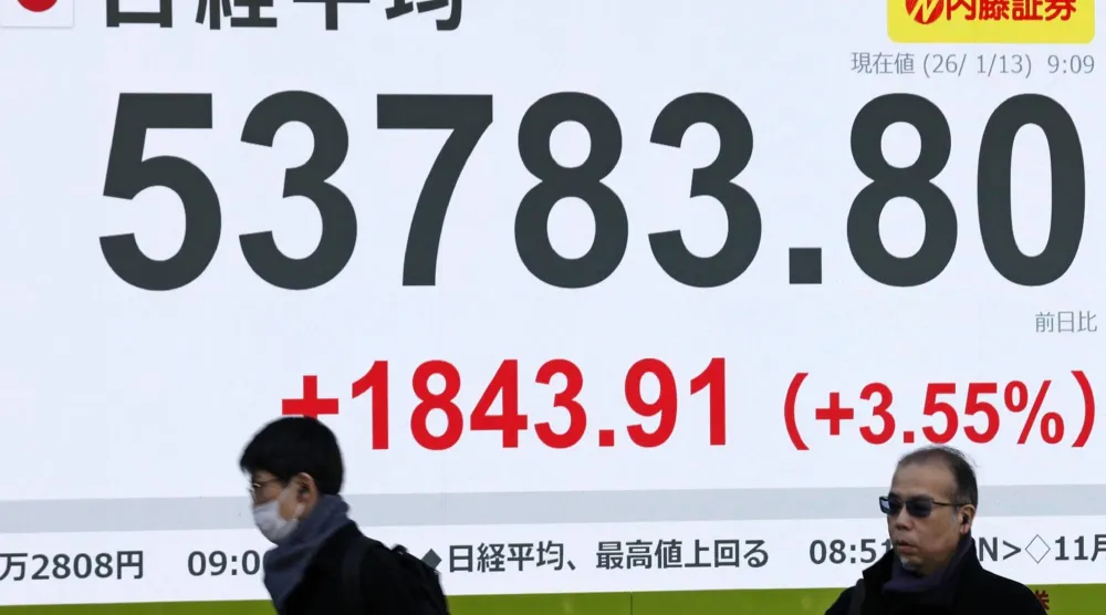 مشاة يمرون أمام شاشة إلكترونية تعرض حركة الأسهم في وسط العاصمة اليابانية طوكيو (أ.ب)