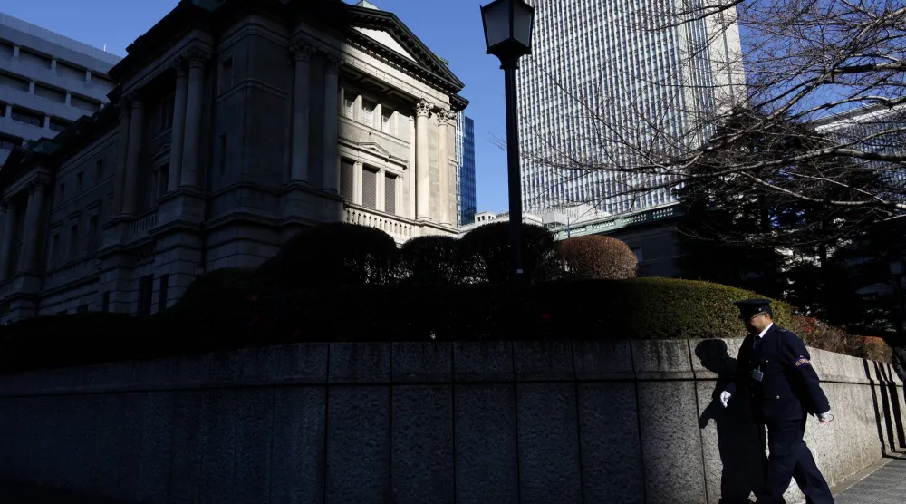 رجل أمن يمر حول السور الخارجي لمقر البنك المركزي في العاصمة اليابانية طوكيو (إ.ب.أ)