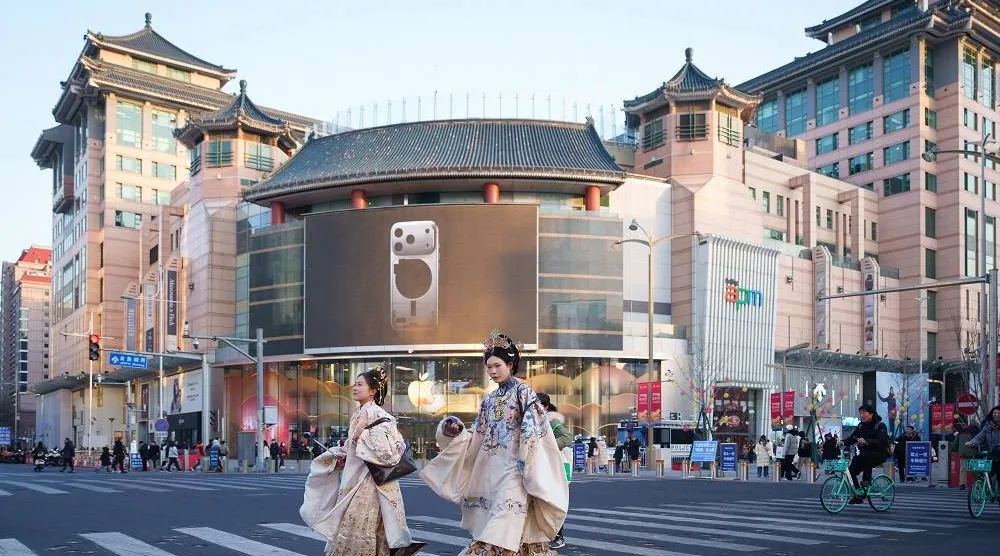 Women dressed in traditional Chinese-style attire cross a street in Beijing, China, Tuesday, Jan. 13, 2026. (AP)
