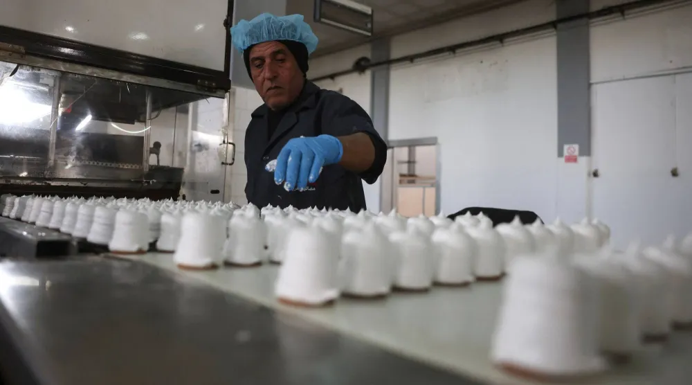 A Palestinian employee inspects sweet locally known as "al-Shatwi" (Winter) Crimbo sweets, as the Al-Arees factory gradually resumes operations after a hiatus caused by the Gaza war which led to shortages of raw materials used in their products, in Deir al-Balah, in the central Gaza Strip on January 12, 2026, following a US-brokered truce that halted the two-year war. (AFP)