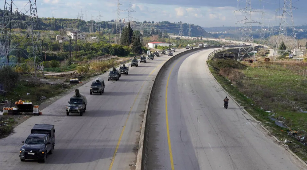 Military vehicles drive along a road as the last Kurdish-led Syrian Democratic Forces (SDF) fighters left the Syrian city of Aleppo on Sunday, state-run Ekhbariya TV said, following a ceasefire deal that allowed evacuations after days of deadly clashes, in Latakia, Syria, January 14, 2026. (Reuters)