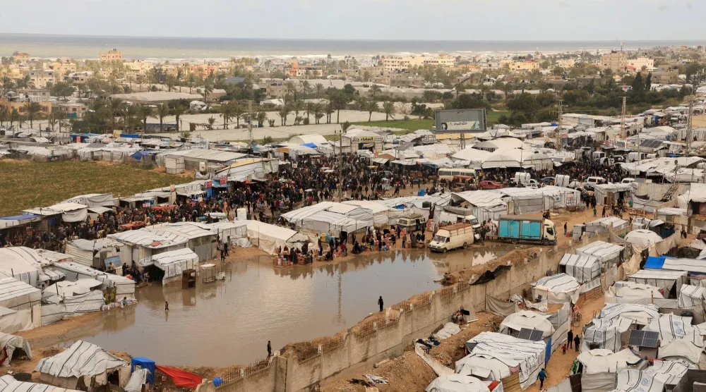 خيام لنازحين فلسطينيين في خان يونس جنوب قطاع غزة تحيط بها مياه الأمطار يوم الأربعاء (رويترز)