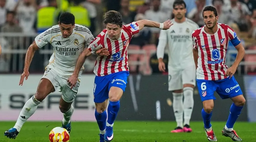 Atletico Madrid's Conor Gallagher, second left, duels for the ball with Real Madrid's Jude Bellingham during the Spanish Super Cup semifinal match at King Abdullah Sports City Stadium in Jeddah, Saudi Arabia, Thursday, Jan. 8, 2026. (AP) 