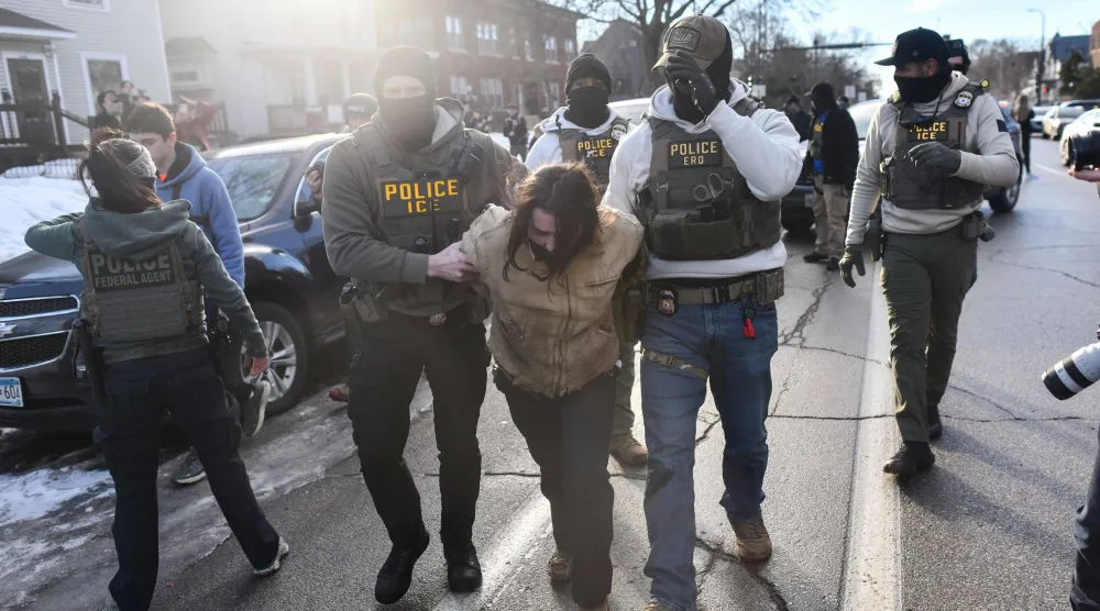 عناصر من إدارة الهجرة والجمارك الأميركية «ICE» وضباط اتحاديون يعتقلون شخصاً خلال احتجاجات في مدينة مينيابوليس بولاية مينيسوتا (أ.ف.ب)