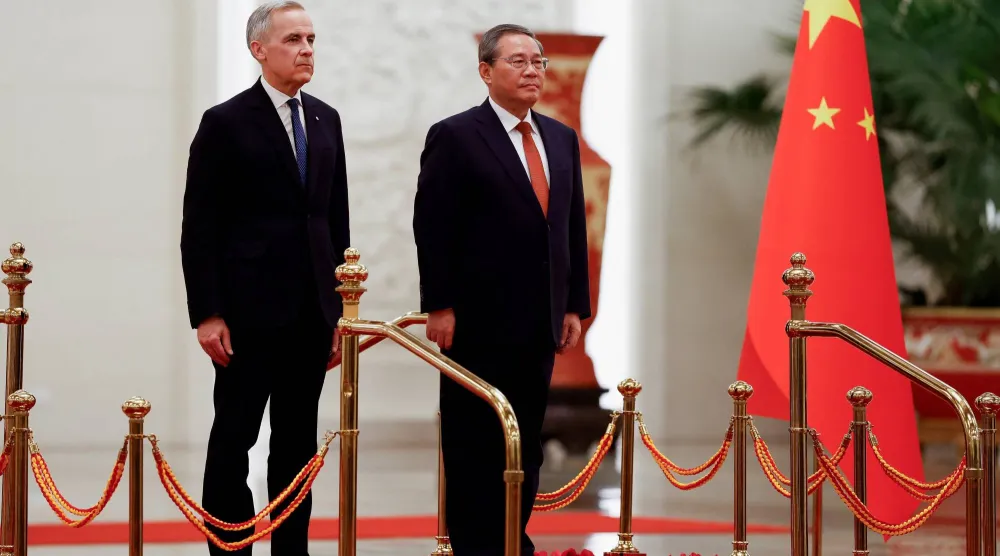 رئيس الوزراء الصيني لي تشيانغ لدى استقباله نظيره الكندي مارك كارني في احتفال رسمي بالعاصمة الصينية بكين (رويترز)