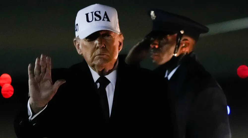 الرئيس الأميركي دونالد ترمب يلوّح بيده بعد وصوله على متن طائرة الرئاسة "إير فورس وان" قادماً من فلوريدا، في 11 يناير 2026، إلى قاعدة أندروز المشتركة في ولاية ماريلاند الأميركية (أ.ب)
