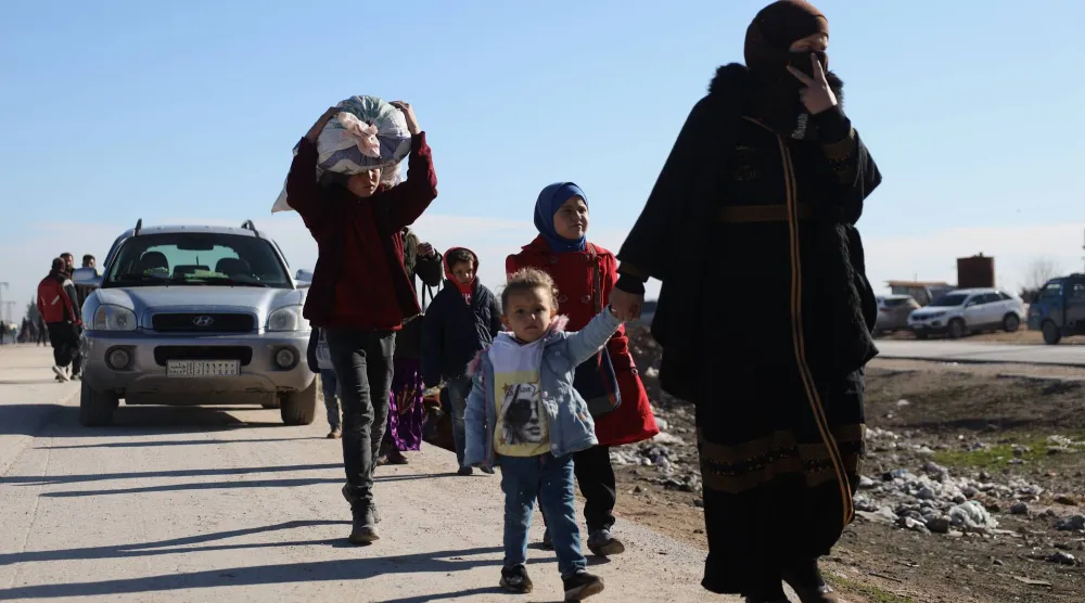 نازحون سوريون بجوار معبر إنساني أعلنه الجيش السوري في قرية حميمة بريف حلب الشرقي قرب خط المواجهة مع «قسد» (أ.ب)