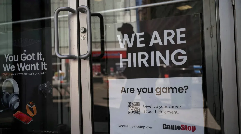 إعلان توظيف معلق على باب متجر في مدينة نيويورك (رويترز)