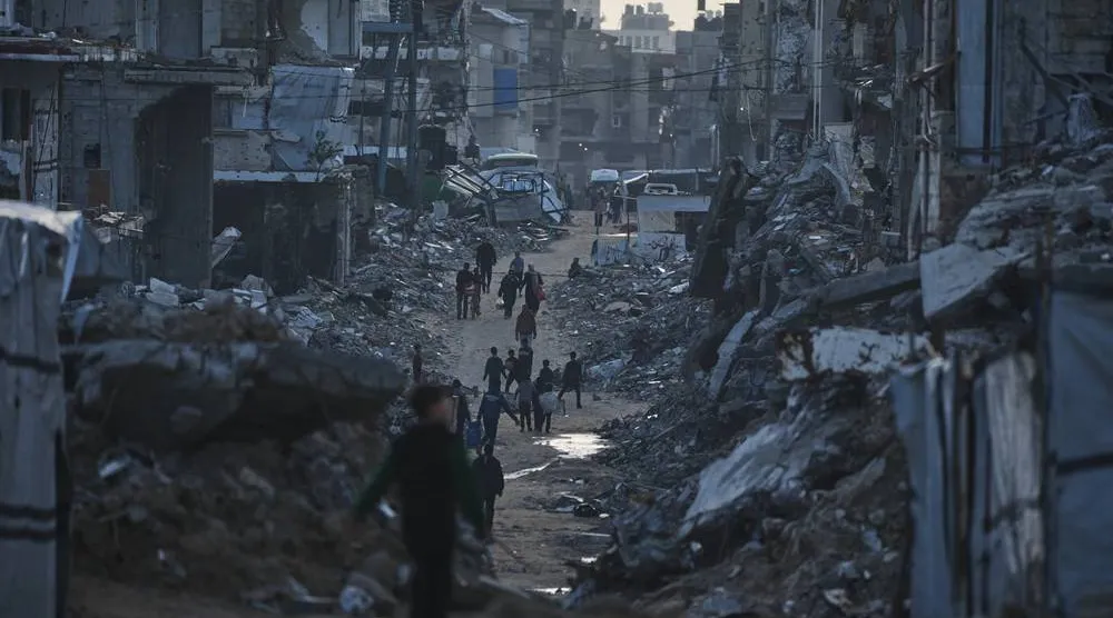  Palestinians walk amid buildings destroyed by Israeli air and ground operations in Gaza City Thursday, Jan. 15, 2026. (AP) 