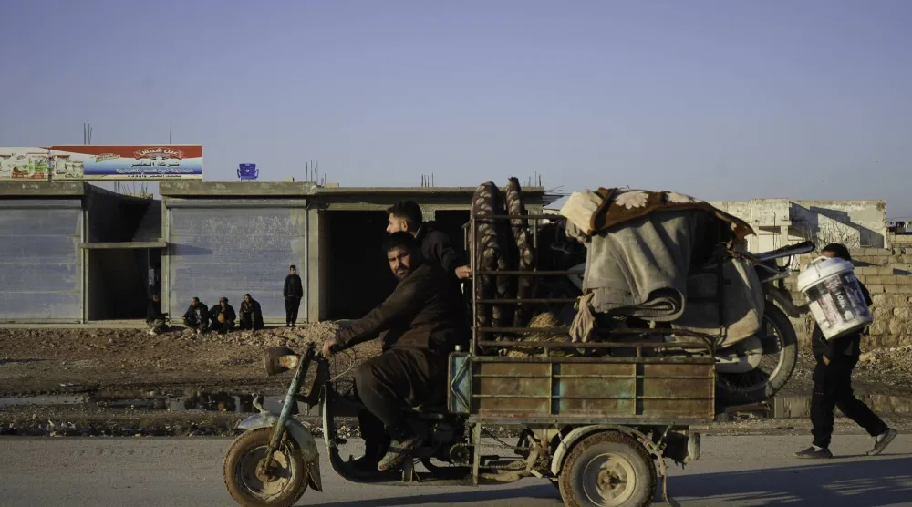 سوريون يغادرون دير حافر (إ.ب.أ)