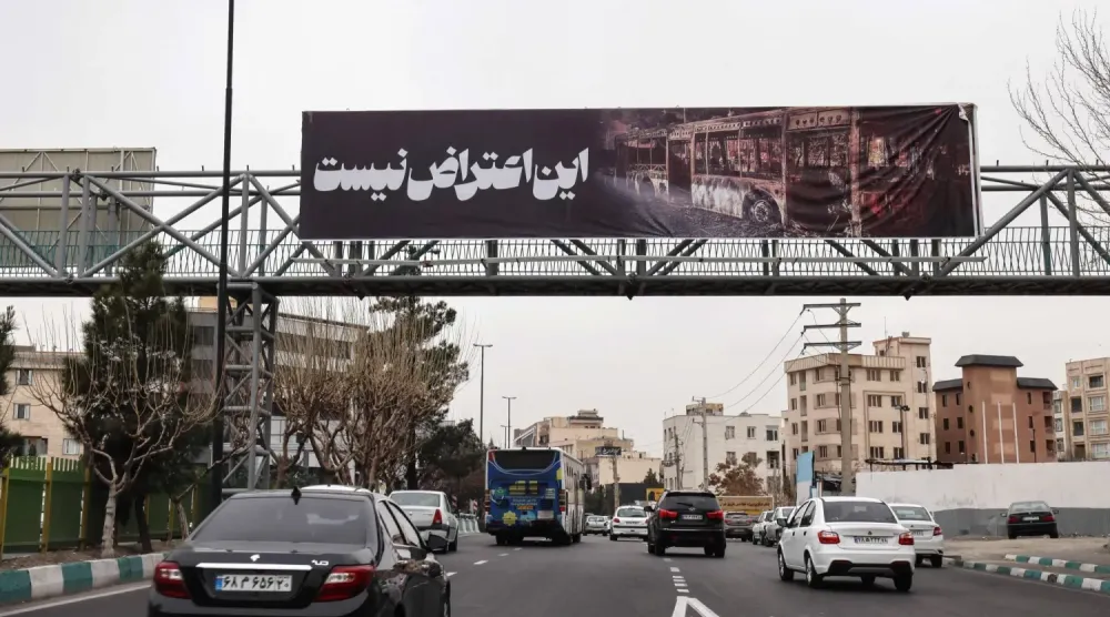 Tahran'da dün "Bu bir protesto değil" yazılı pankart taşıyan arabalar sokaklarda dolaştı (AFP)