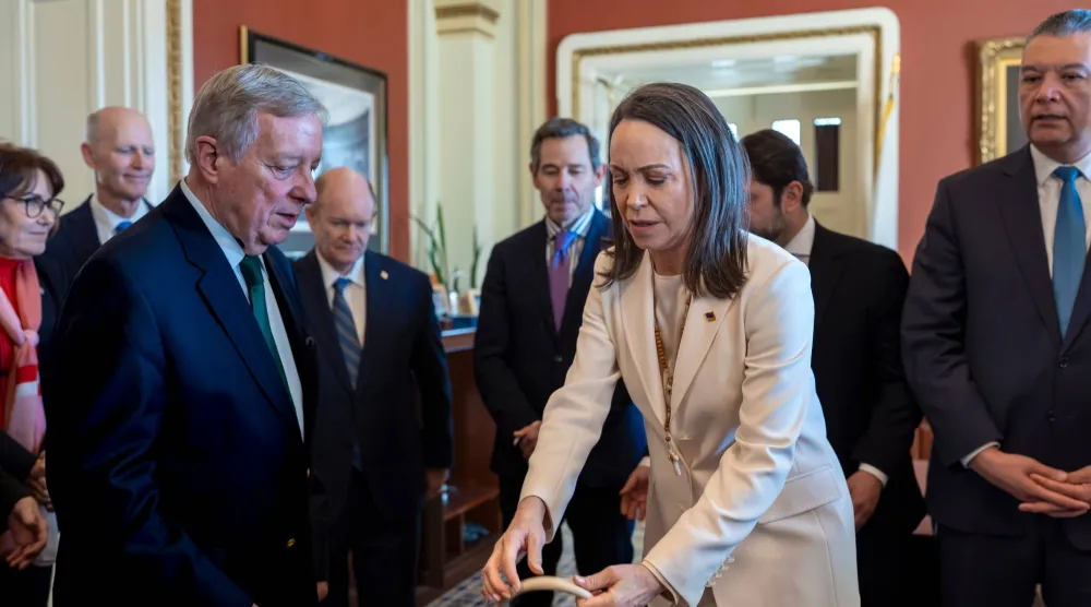 زعيمة المعارضة الفنزويلية ماريا كورينا ماتشادو لدى وصولها إلى مقر الكونغرس الأميركي في واشنطن... ويبدو إلى جانبها السيناتور ديك دوربن (أ.ب)