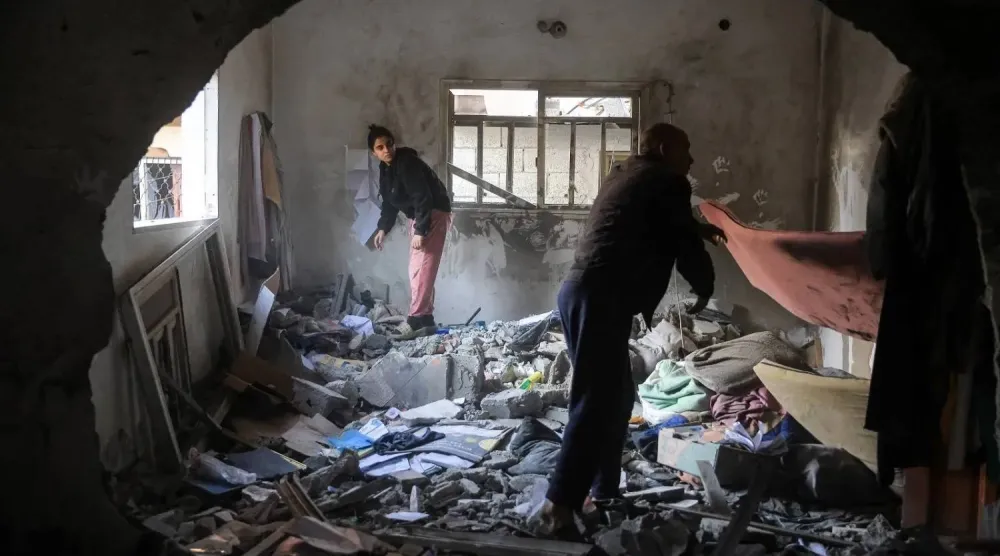 Palestinians salvage belongings from a home after an Israeli military attack west of Deir al Balah in central Gaza (AFP)