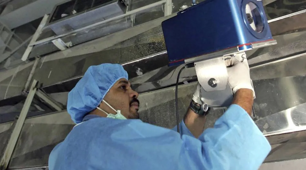 مفتش من «الطاقة الذرية» يركّب كاميرات للمراقبة بمنشأة «نطنز» في أغسطس 2005 (أ.ب)