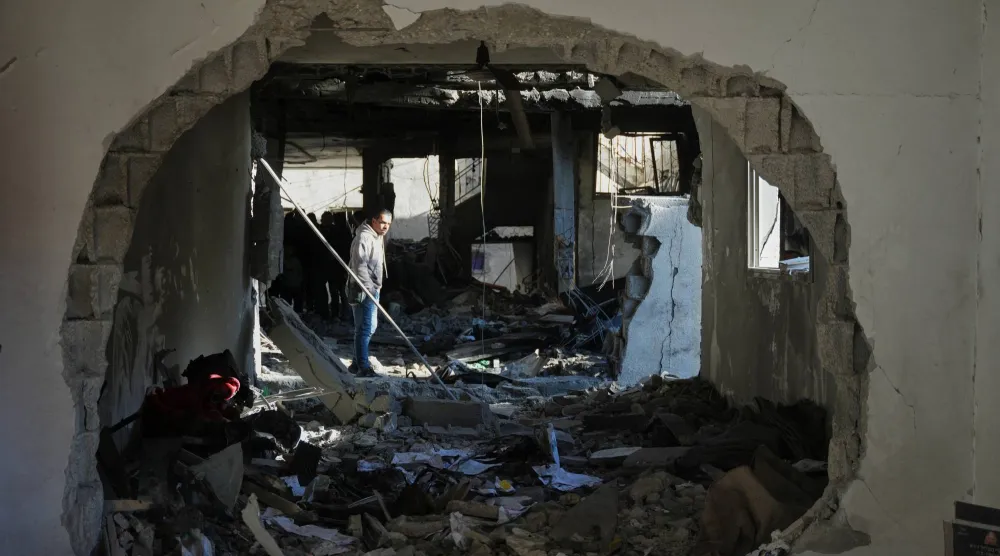 فلسطيني يعلين الدمار الذي خلفته ضربة إسرائيلية في منزل بدير البلح وسط قطاع غزة أمس (أ.ب)