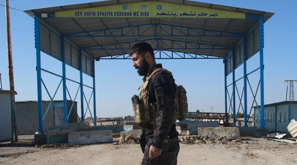 "Suriye Demokratik Güçleri"nden bir savaşçı, Deyr Hafir-Halep yolundaki bir kontrol noktasında (AP)