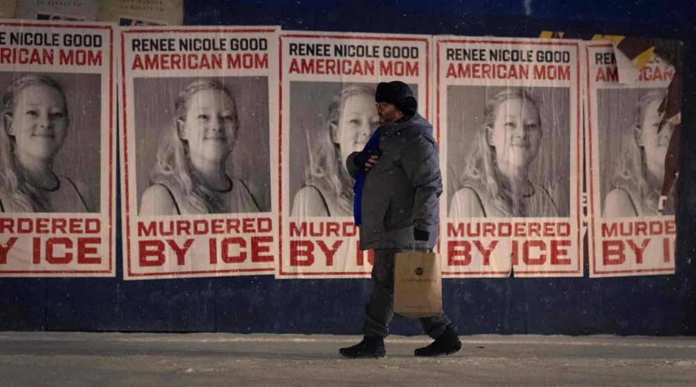 رجل يمر بجوار مجموعة من الملصقات التذكارية لرينيه غود في 16 يناير 2026 بمينيابوليس (أ.ف.ب)