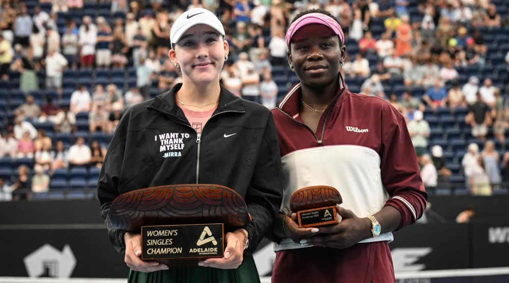 الروسية ميرا أندرييفا (يسار) تحتفل بكأس أديلايد إلى جوار الكندية فيكتوريا مبوكو (أ.ف.ب)