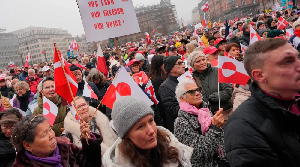 لوّح متظاهرون بأعلام غرينلاند خلال مشاركتهم في مسيرة أمام مبنى بلدية كوبنهاغن - الدنمارك (أ.ف.ب)