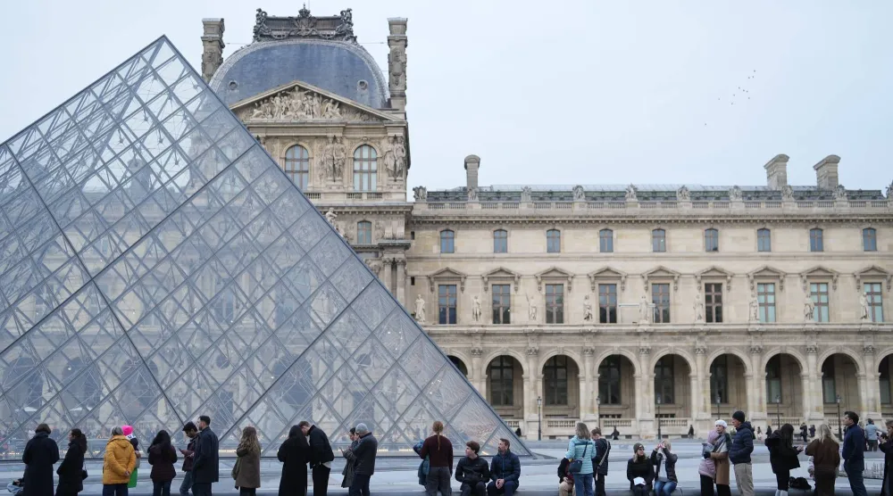 FILE - People wait for the Louvre museum to open, Thursday, Dec. 18, 2025 in Paris. (AP Photo/Thibault Camus, File)
