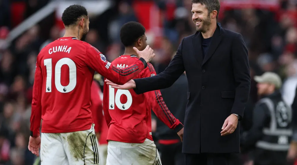 مايكل كاريك مدرب يونايتد الجديد يحتفل مع لاعبيه بالفوز في الديربي (رويترز)