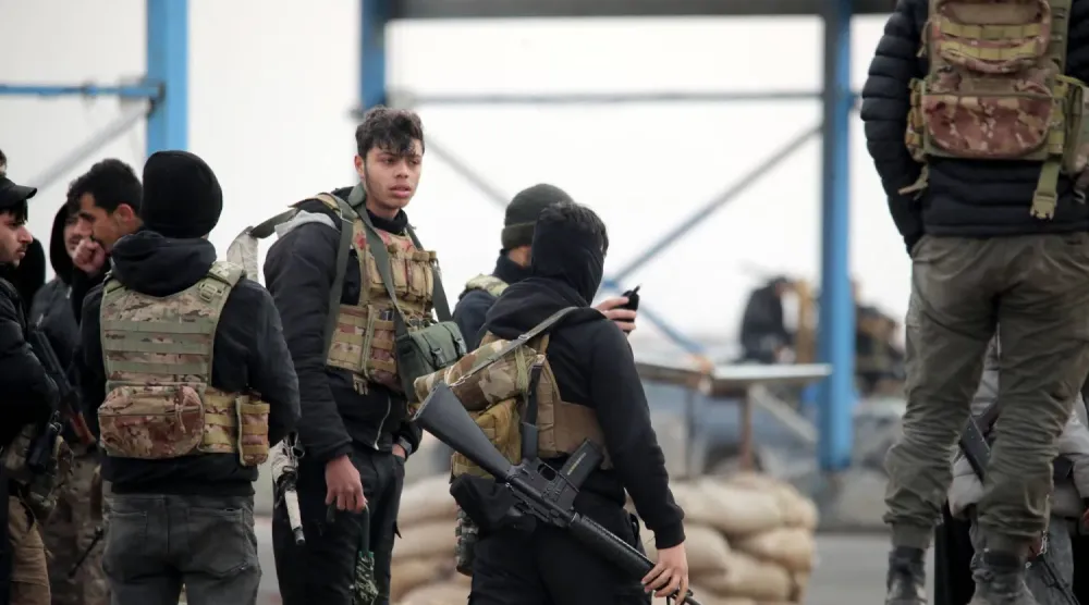 Suriye'nin kuzeyindeki Rakka ilinin Tabka ilçesinin girişindeki Kürt güçleri (AFP)