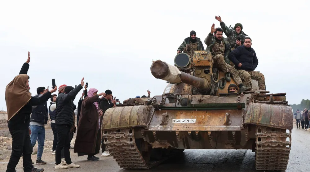 جنود سوريون يدخلون على ظهر دبابة مدينة مسكنة في ريف حلب الشرقي بعد انسحاب قوات «قسد» منها أمس (أ.ف.ب)