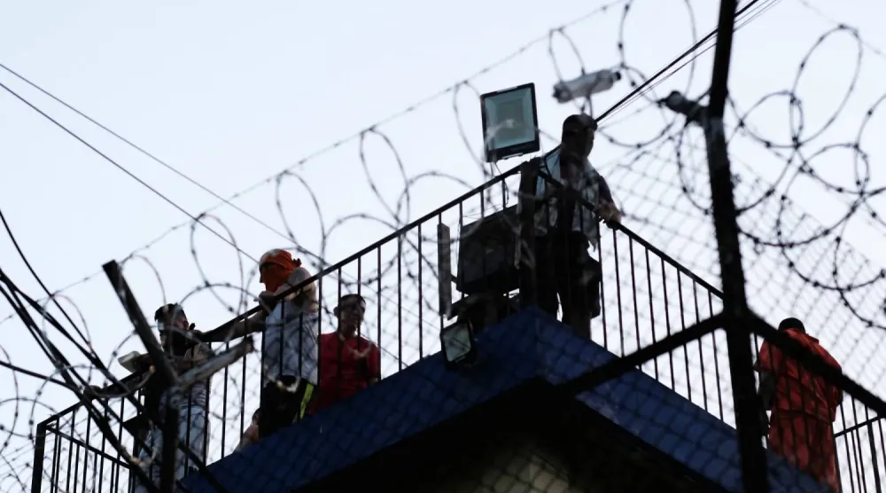 Guatemala'daki üç hapishanede isyanlar patlak verirken, Renovación hapishanesindeki mahkumlar gözetleme kulesinde toplandı (Reuters)