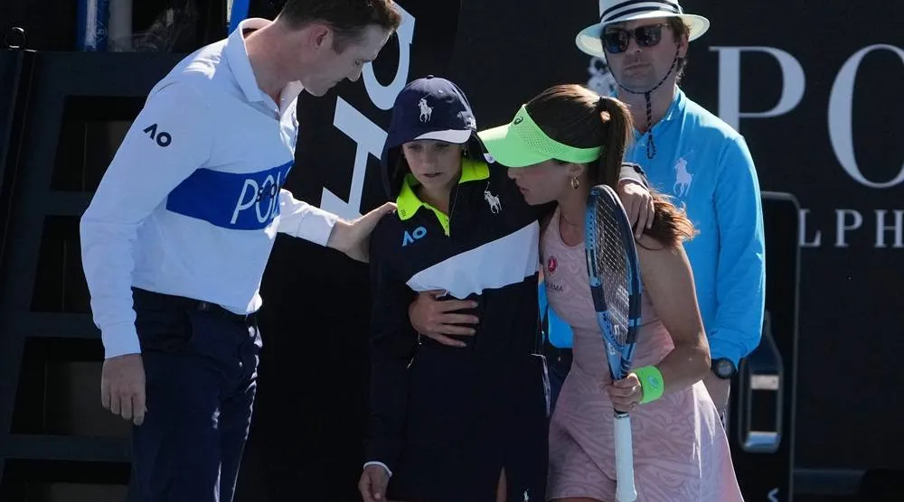  Zeynep Sonmez of Türkiye and umpire Chase Urban help a ball kid who fainted, from the court during her first round match against Ekaterina Alexandrova of Russia at the Australian Open tennis championship in Melbourne, Australia, Sunday, Jan. 18, 2026. (AP) 