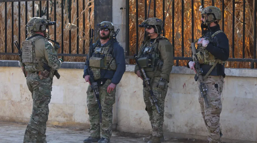 جنود أميركيون من التحالف الذي تقوده الولايات المتحدة ضد تنظيم «داعش» يقفون في حالة تأهب خلال اجتماع مع «قوات سوريا الديمقراطية» بدير حفر بسوريا أول من أمس (أ.ب)